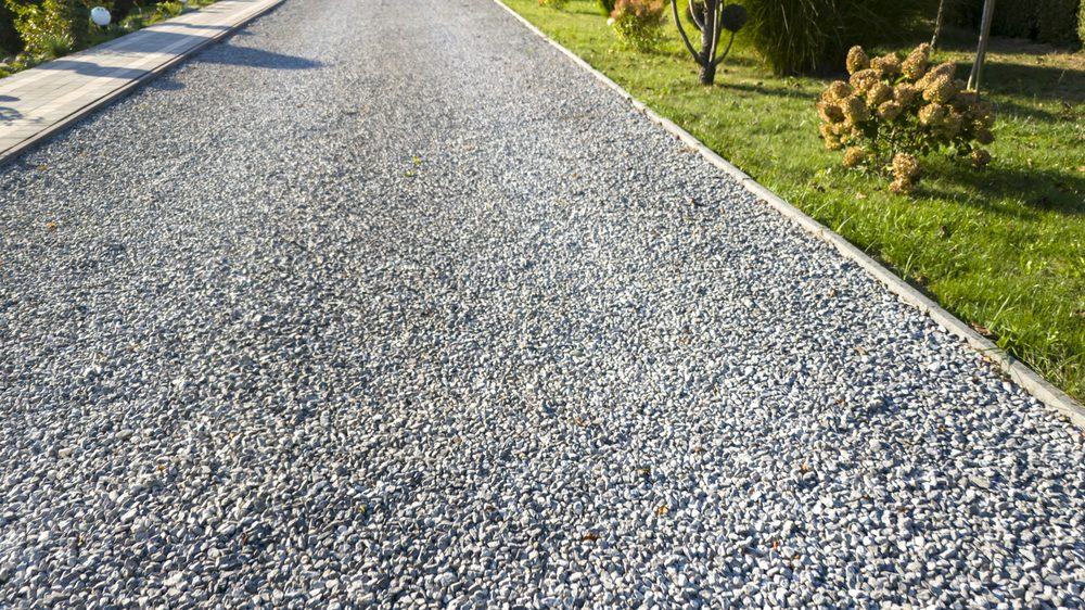A finished gravel driveway beside a lawn